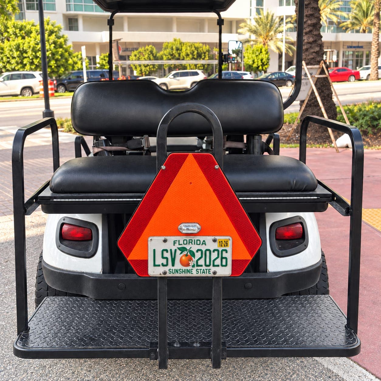 Rear of a street legal golf cart in Florida with a Low Speed Vehicle license plate and slow moving vehicle emblem